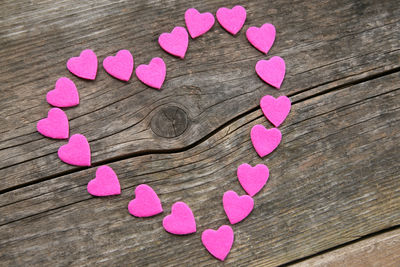 High angle view of pink heart shaped flower on wooden table