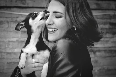 Close-up of smiling young woman holding horse