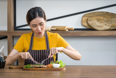 Young woman preparing food on table