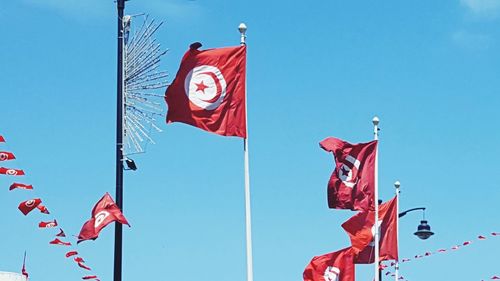 Low angle view of tunisian flags against clear sky