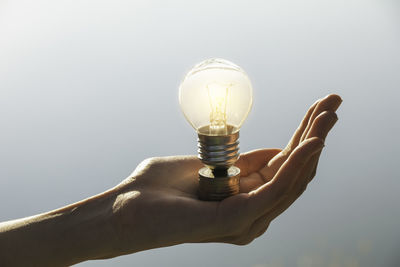 Close-up of hand holding light bulb