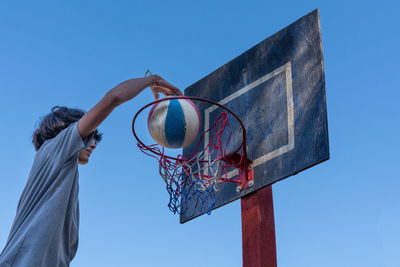 Low angle view of basketball hoop against blue sky