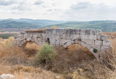 Old ruins on landscape against sky