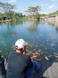 Rear view of man sitting in lake