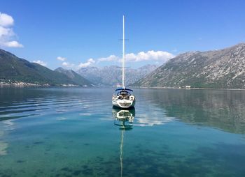 Scenic view of lake and mountains against blue sky