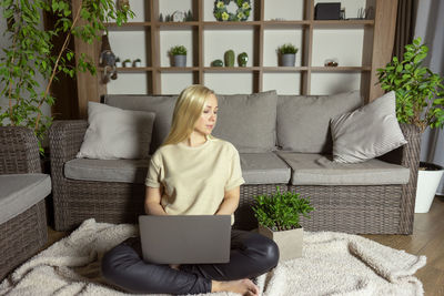 Woman sitting on sofa at home