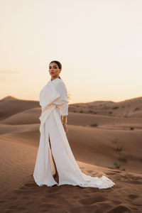 Portrait of woman standing at desert