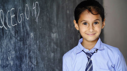 Portrait of young man standing against wall