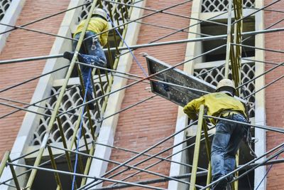 Low angle view of man working on window