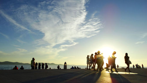 Group of people on beach at sunset