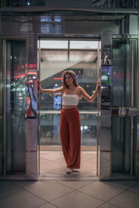 Full length of woman standing at elevator doorway