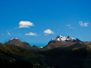 Scenic view of mountains against blue sky