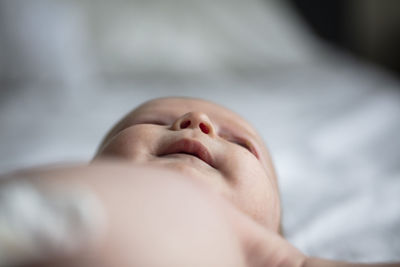 Close-up of baby sleeping on bed