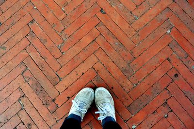 Low section of man standing on cobblestone