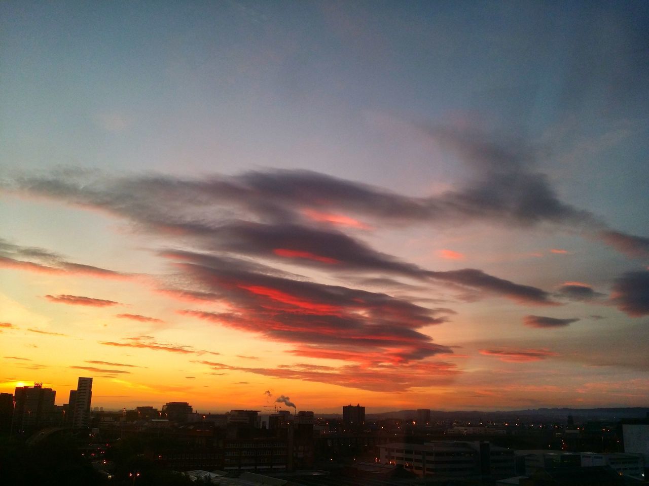 SILHOUETTE BUILDINGS IN CITY AGAINST SKY DURING SUNSET