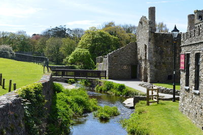 Bridge over river against sky and ruins