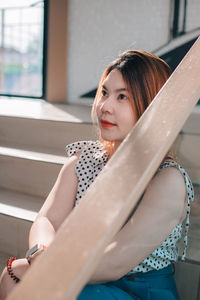 Portrait of young woman sitting on sofa at home