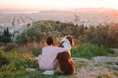 Rear view of man and dog looking at mountain