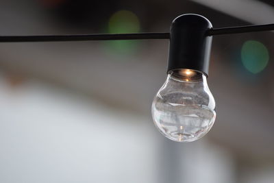 Close-up of light bulb hanging on cable
