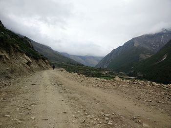 Scenic view of road by mountains against sky