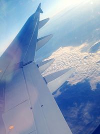 Cropped image of airplane flying over clouds