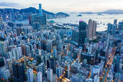 Aerial view of buildings in city against sky at dusk