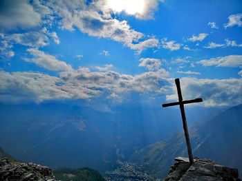 Low angle view of cross on mountain against sky