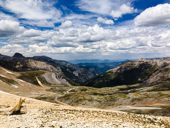 Scenic view of mountain range against cloudy sky