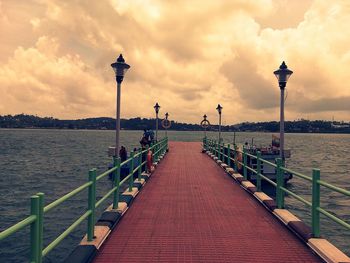 View of pier on sea against cloudy sky