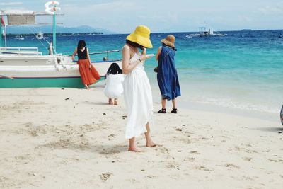 Rear view of women standing on beach