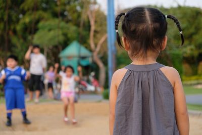 Rear view of girl standing at park