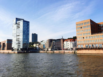 River by buildings against sky in city