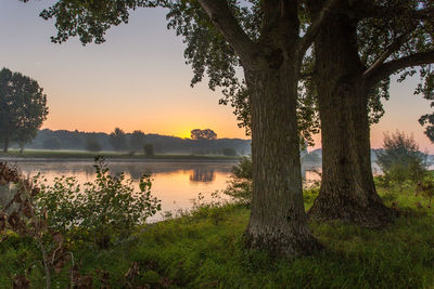 Scenic view of lake against sky at sunset