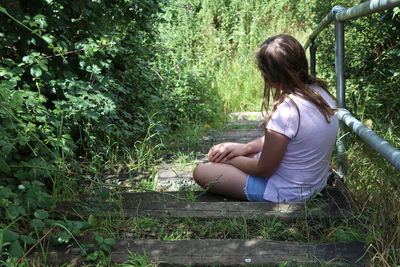 Full length of woman sitting on land