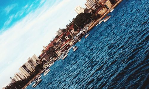 Tilt image of building by sea against sky