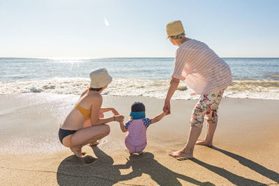 Rear view of woman standing at beach