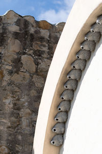 Close-up of wall by building against sky