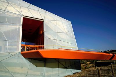 Low angle view of modern building against clear blue sky