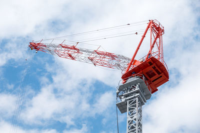 Low angle view of crane at construction site against sky