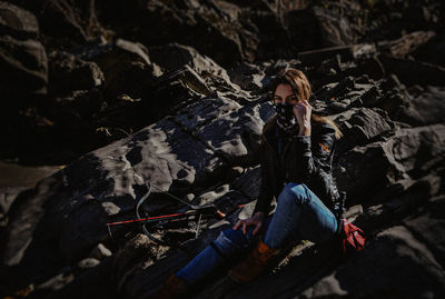 High angle view of young woman on rock