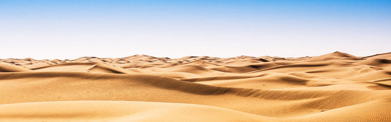 Sand dunes in desert against clear sky