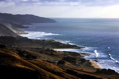 Scenic view of sea and mountains against sky