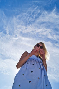 Low angle view of woman standing against sky