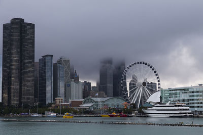 Boats docked at navy pier seen from lake michigan, with chicago skyscrapers shrouded in mist