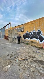 Rear view of people on wall against sky