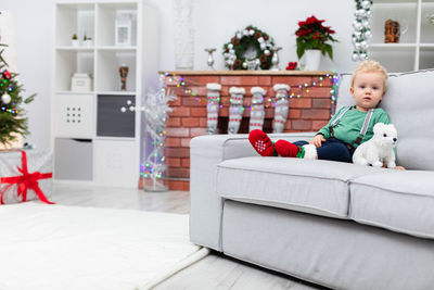 Portrait of woman sitting on sofa at home