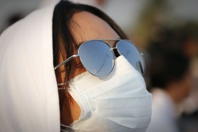 Close-up of woman wearing sunglasses and face mask