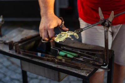 Midsection of person working on metal