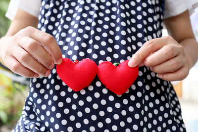 Midsection of woman holding heart shape