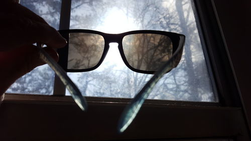 Close-up of eyeglasses on sunglasses against sky